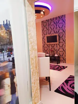 a room with a white chair and a tv at Gold in Belgrade