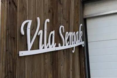 a sign on the side of a building with a garage at Vila Senjak in Belgrade