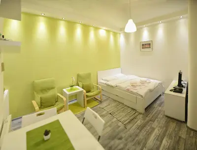 a small room with a bed and two chairs at Kate Apartment Belgrade in Belgrade