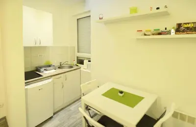 a small kitchen with a table and a sink at Kate Apartment Belgrade in Belgrade