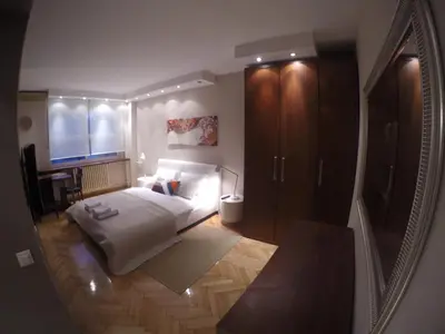 a bedroom with a bed and a desk and a mirror at Apartments near St. Sava Temple in Belgrade