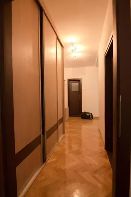 an empty hallway with a door and wooden floors at Apartments near St. Sava Temple in Belgrade
