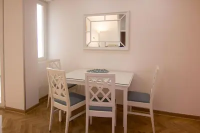 a dining room table with two chairs and a mirror at Apartments near St. Sava Temple in Belgrade