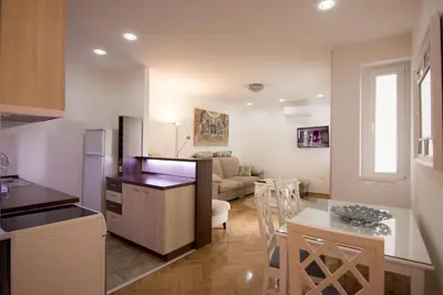 a kitchen and living room with a couch and a table at Apartments near St. Sava Temple in Belgrade