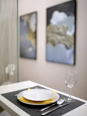 a table with a plate and a glass of wine at Main Square Residence in Belgrade