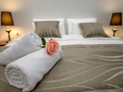a towel with a rose on top of a bed at Main Square Residence in Belgrade