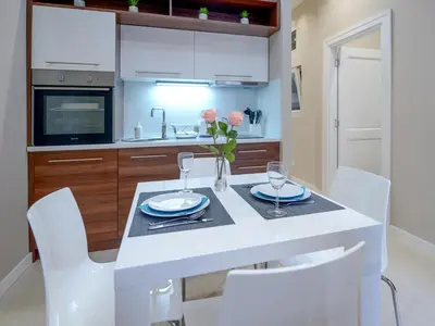 a kitchen with a white table and white chairs at Main Square Residence in Belgrade