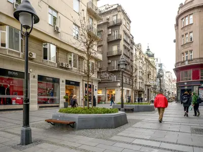 a woman walking down a street in a city at Main Square Residence in Belgrade
