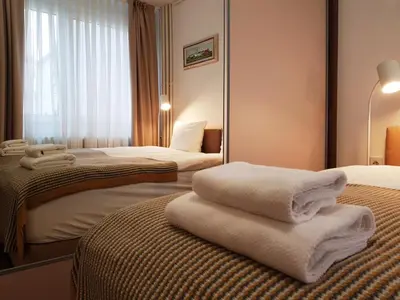 two beds in a hotel room with towels on the beds at Dafni Apartment in Belgrade