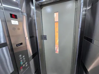 a metal elevator with a door with a window at Dafni Apartment in Belgrade