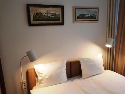 a bed with two pillows and two pictures on the wall at Dafni Apartment in Belgrade