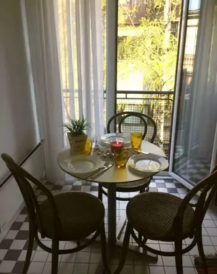 a table with two chairs and a table with food on a balcony at Apartment Jastuk in Belgrade