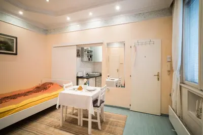 a bedroom with a bed and a table and chairs at White Pearl Apartment in Belgrade