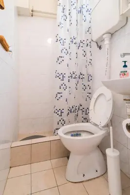 a bathroom with a toilet and a shower curtain at White Pearl Apartment in Belgrade
