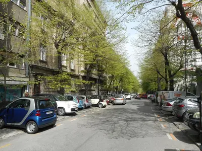 a street with cars parked on the sides of the road at White Pearl Apartment in Belgrade