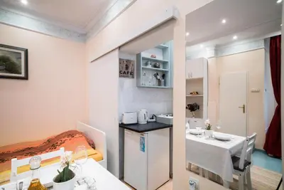 a small room with a bed and a dining room at White Pearl Apartment in Belgrade