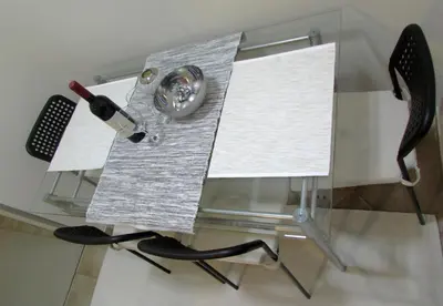 a glass table with a bottle of wine and two chairs at Apartment B&S in Belgrade