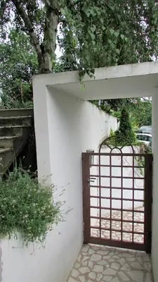 a gate in a white wall with a plant at Apartment B&S in Belgrade