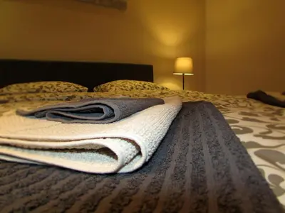 a blanket on a bed in a bedroom with a lamp at Apartment B&S in Belgrade
