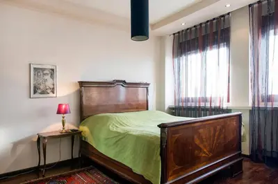 a bedroom with a bed with green sheets and a window at Roof Penthouse 15th Floor in Belgrade