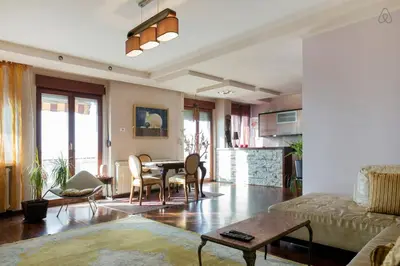 a living room with a table and a couch at Roof Penthouse 15th Floor in Belgrade