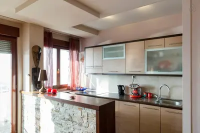 a kitchen with wooden cabinets and a counter top at Roof Penthouse 15th Floor in Belgrade