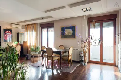 a living room with a dining room table and chairs at Roof Penthouse 15th Floor in Belgrade