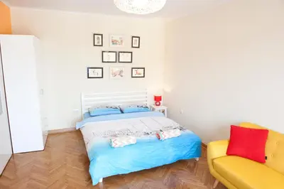 a bedroom with a bed and a yellow couch at Atelje apartment in Belgrade