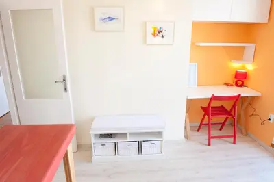 a small room with a desk and a red chair at Atelje apartment in Belgrade