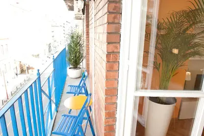 a blue balcony with a blue railing and a yellow chair at Atelje apartment in Belgrade