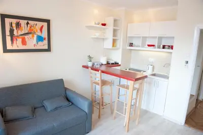 a living room with a couch and a kitchen with a table at Atelje apartment in Belgrade
