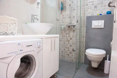 a bathroom with a washing machine and a sink at Atelje apartment in Belgrade