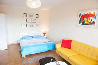 a bedroom with a bed and a yellow couch at Atelje apartment in Belgrade