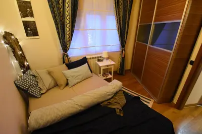 a living room with a couch in front of a window at Charming Flat with Soul in Belgrade