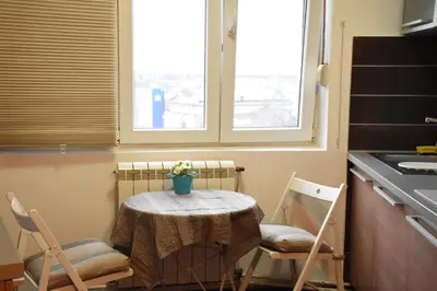 a small table and chairs in a kitchen with a window at Charming Flat with Soul in Belgrade