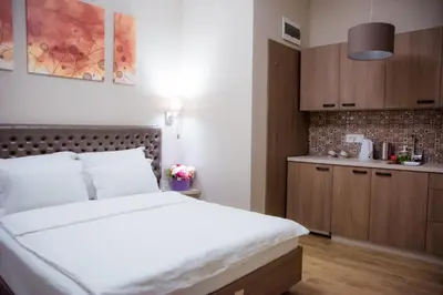 a bedroom with a large bed and a kitchen at Apartments Srbija - FREE PARKING in Belgrade