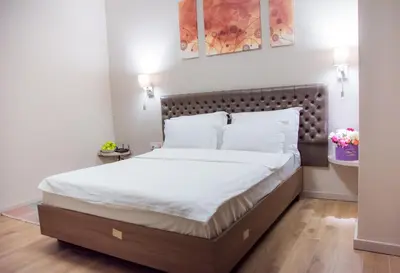 a bedroom with a large bed with white sheets at Apartments Srbija - FREE PARKING in Belgrade