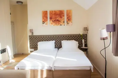 two beds in a hotel room with white sheets at Apartments Srbija - FREE PARKING in Belgrade