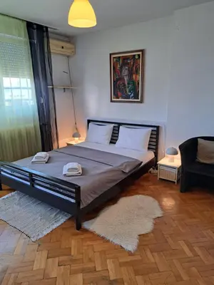 a bedroom with a large bed with a rug at Apartman Centar Beograd in Belgrade