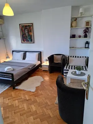 a bedroom with a bed and a couch and a chair at Apartman Centar Beograd in Belgrade