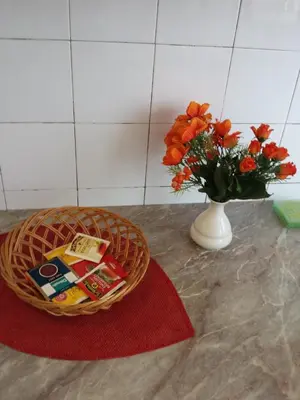 a basket on a counter with a vase with orange flowers at Apartman Centar Beograd in Belgrade