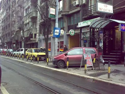 a red car parked on the side of a city street at Apartman Centar Beograd in Belgrade