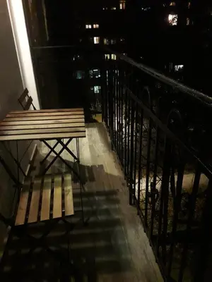 a bench sitting on a balcony at night at Momo Apartment in Belgrade
