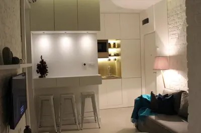 a kitchen with a bar with stools in a living room at Momo Apartment in Belgrade