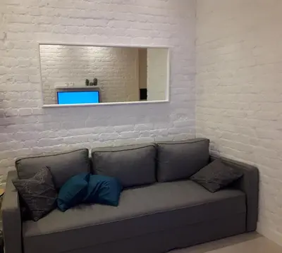 a living room with a couch and a mirror at Momo Apartment in Belgrade