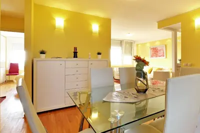 a dining room with a glass table and white chairs at Apartment Bella Art in Belgrade