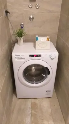 a white washing machine with a plant on top of it at Apartman Centar Bg in Belgrade