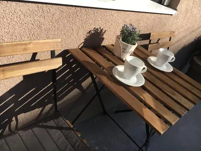 a wooden table with two cups and saucers on it at Apartman Centar Bg in Belgrade