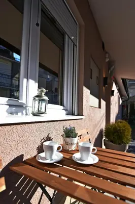 a wooden table with two cups and saucers on it at Apartman Centar Bg in Belgrade