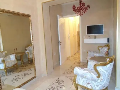 a living room with a mirror and a chair at Apartment Bourgeois in Belgrade